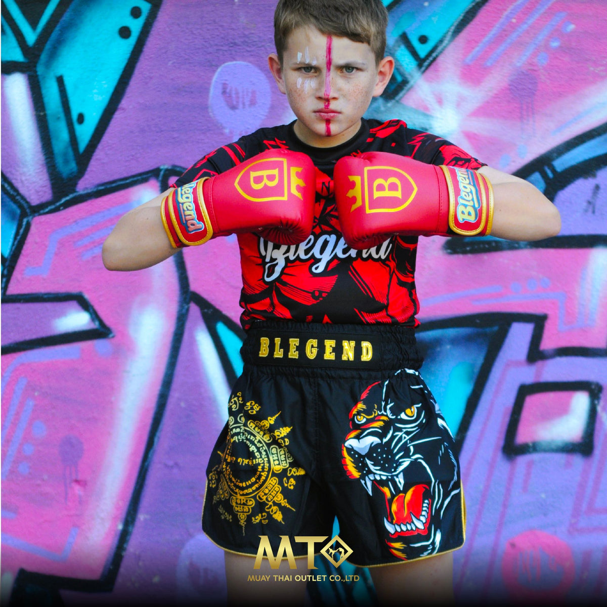 Kid in Blegend boxing gloves and Muay Thai shorts